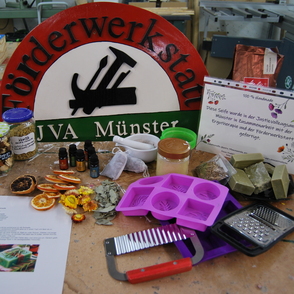 Schild der F&ouml;rderwerkstatt JVA M&uuml;nster und diverse Utensilien zur Seifenherstellung