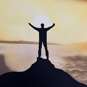 Kunstwerk Mann als Schatten auf einem Berggipfel vor der Sonne