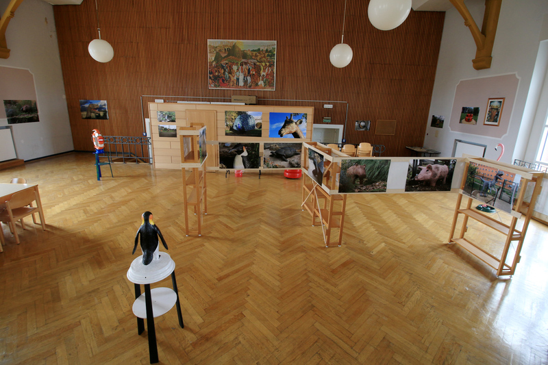 Die Aufnahme aus einer anderen Richtung zeigt einen Überblick über die Ausstellung von Fotografien und Skulpturen in der Kirche von Haus 1.