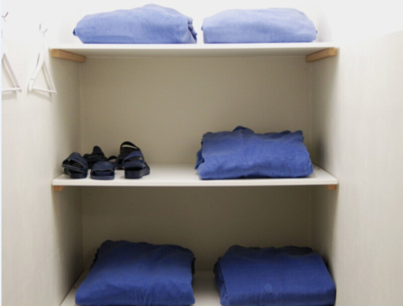 Haftraumschrank mit ordentlich gestapelter Kleidung