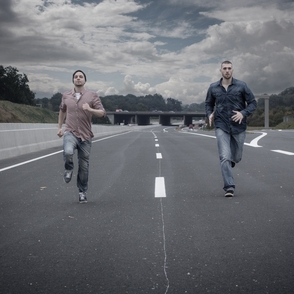 Die beiden Musiker joggen auf einer Leeren Autobahn