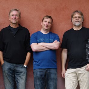 Bandfoto vor einer terracottafarbenen Hauswand