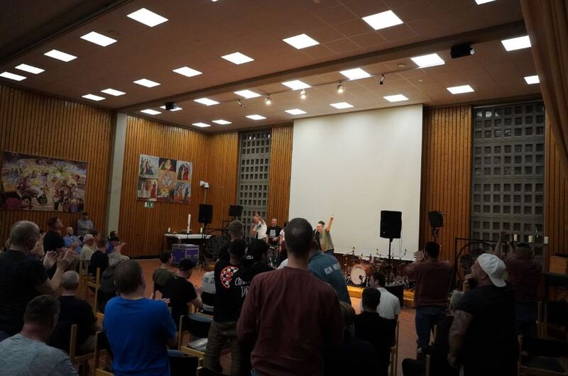 Die Band Groovemax auf der Bühne in der Anstaltskirche heben die Arme