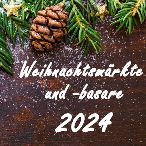 Tannenzweige und Christbaumschmuck auf einem dunklen Holzbrett