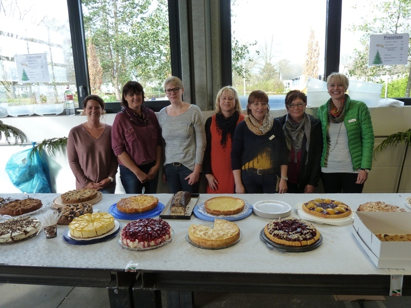 Damen hinter der Kuchentheke präsentieren ihr Kuchen und Torten